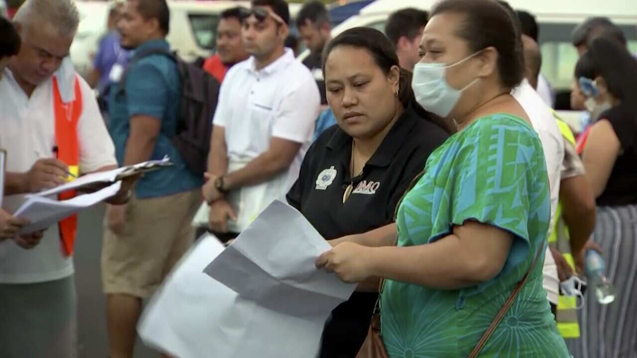 People gather outside a health emergency operation center Thursday, Dec. 5, 2019, in Apia, Samoa.