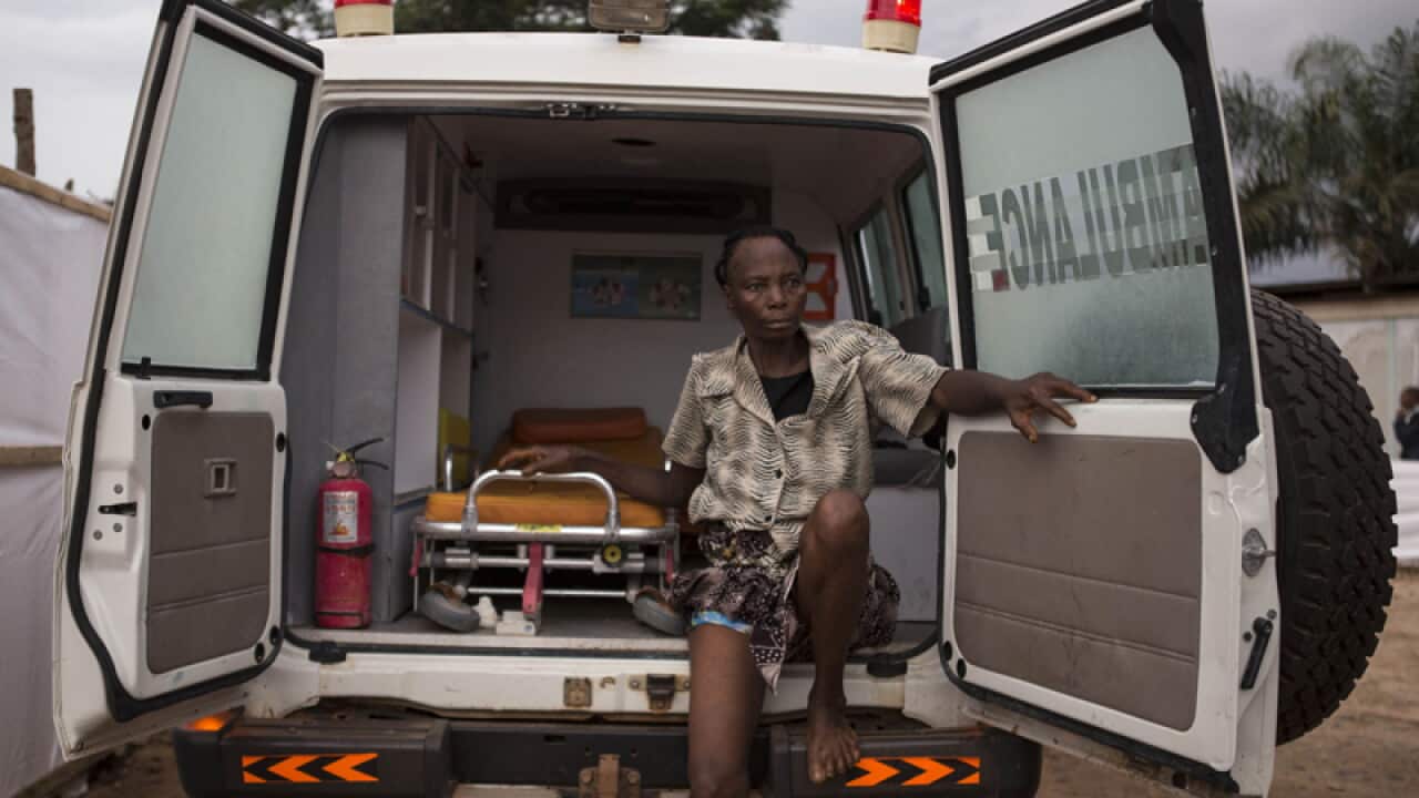 A woman suspected of suffering from Ebola sits in an ambulance