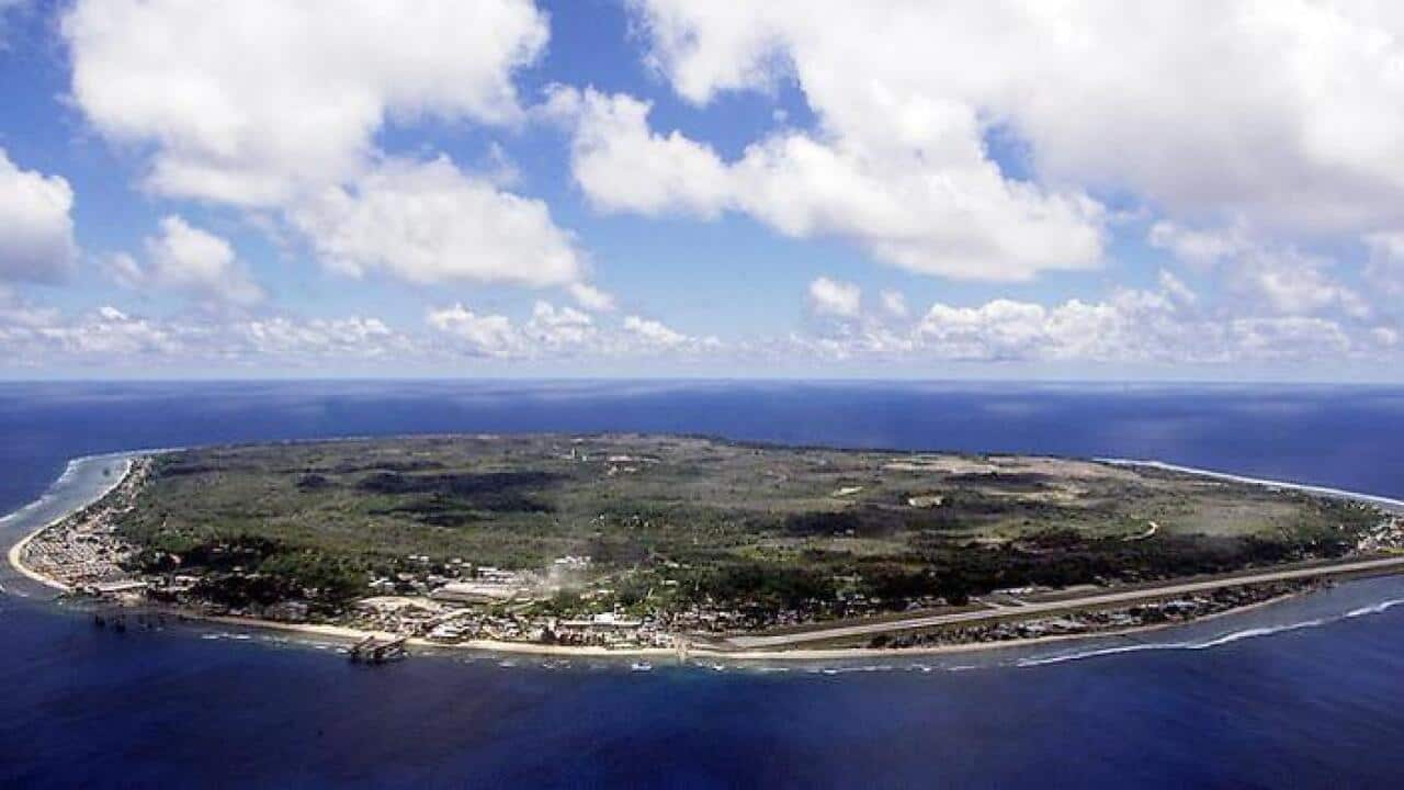 An aerial view of a green island surrounded by blue waters.