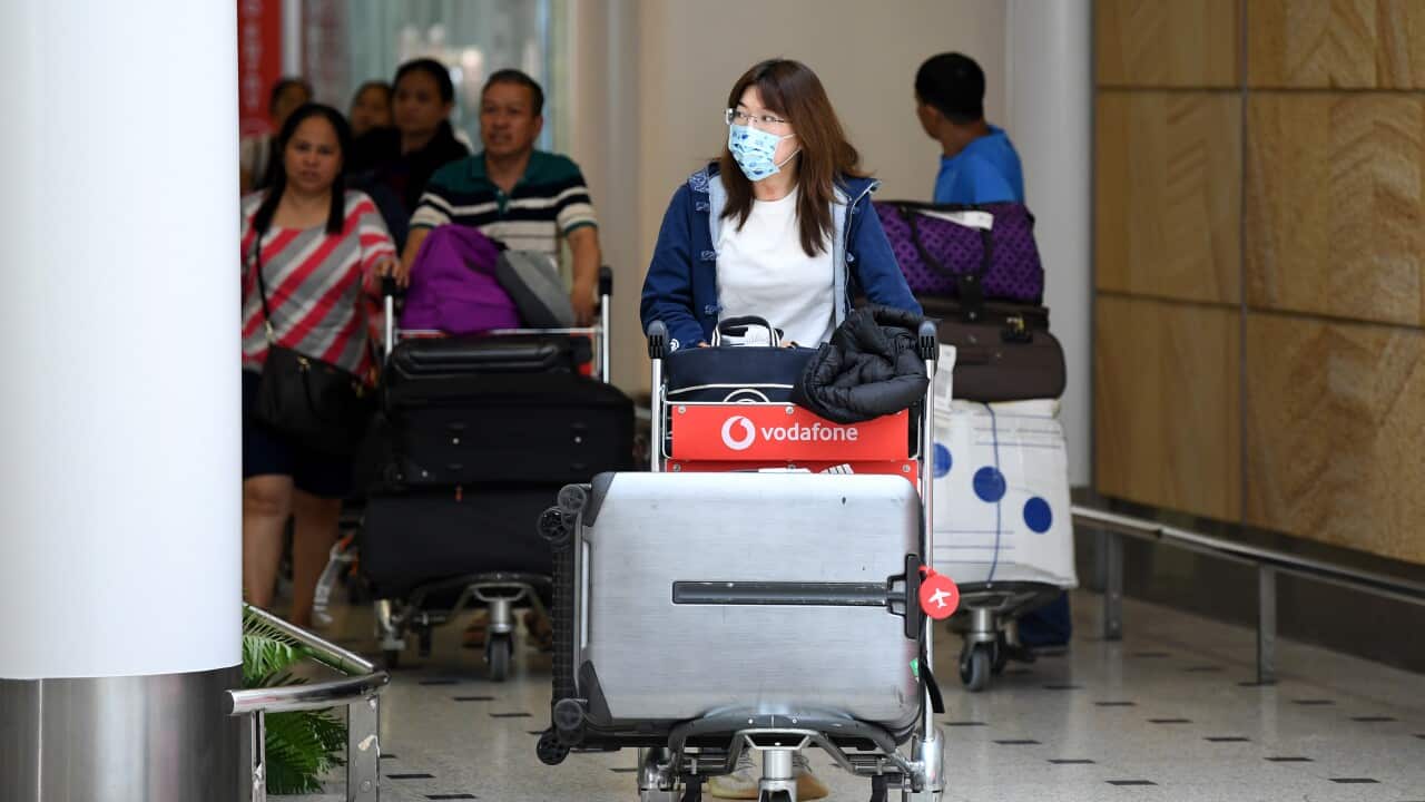 Passengers wearing protective masks arrive at Sydney International Airport in Sydney, Thursday, 23 January, 2020.