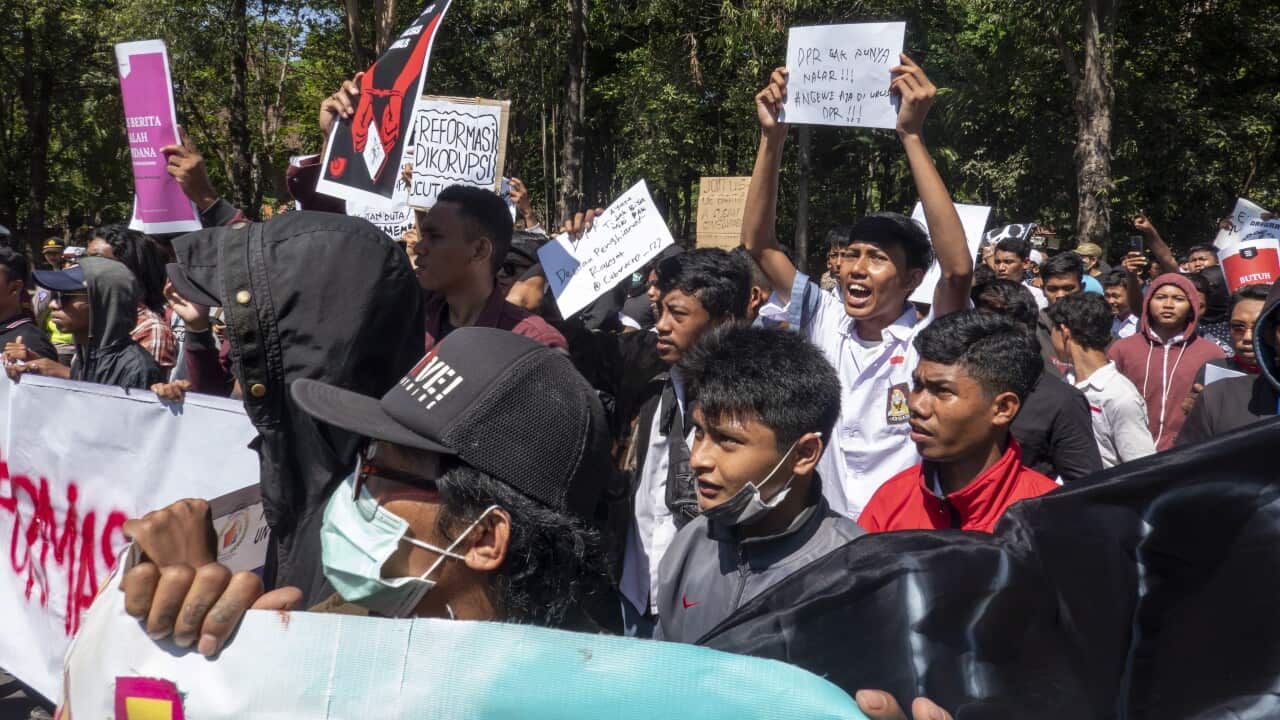 Indonesian students hold placards during a protest at a main street in Denpasar, Bali.