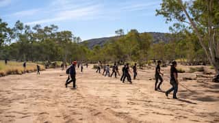 Emergency services and volunteers scour thick scrub and terrain near Alice Springs.