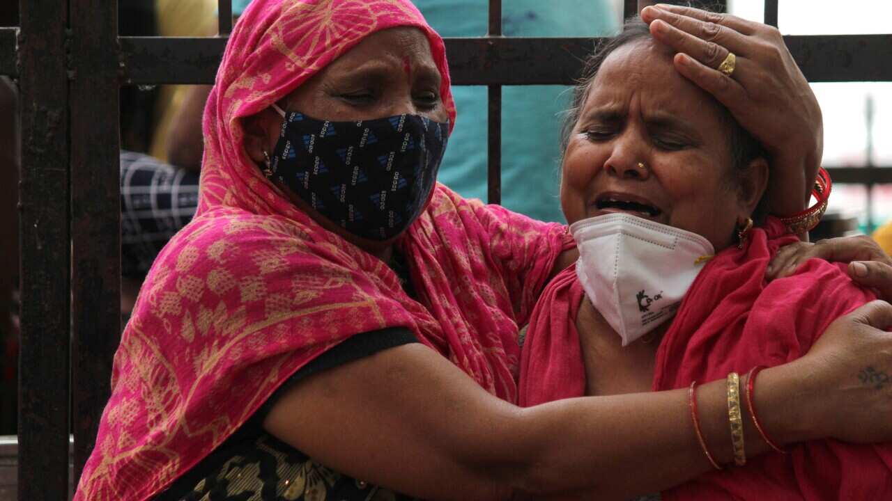 Women mourn the death of a family member who died from COVID-19, outside the Lok Nayak Jai Prakash Narayan Hospital in New Delhi, India on 4 May.