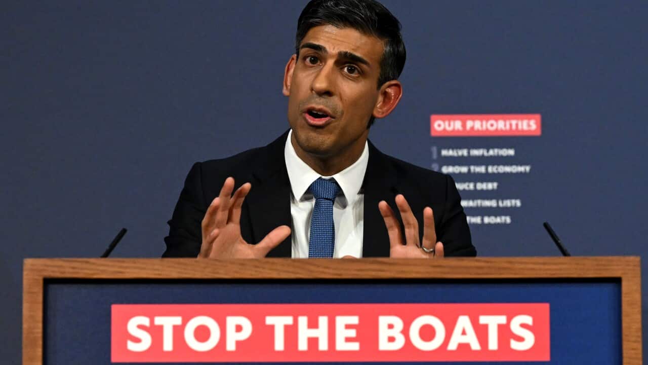 Prime Minister Rishi Sunak during a press conference above a sign that reads 'stop the boats'