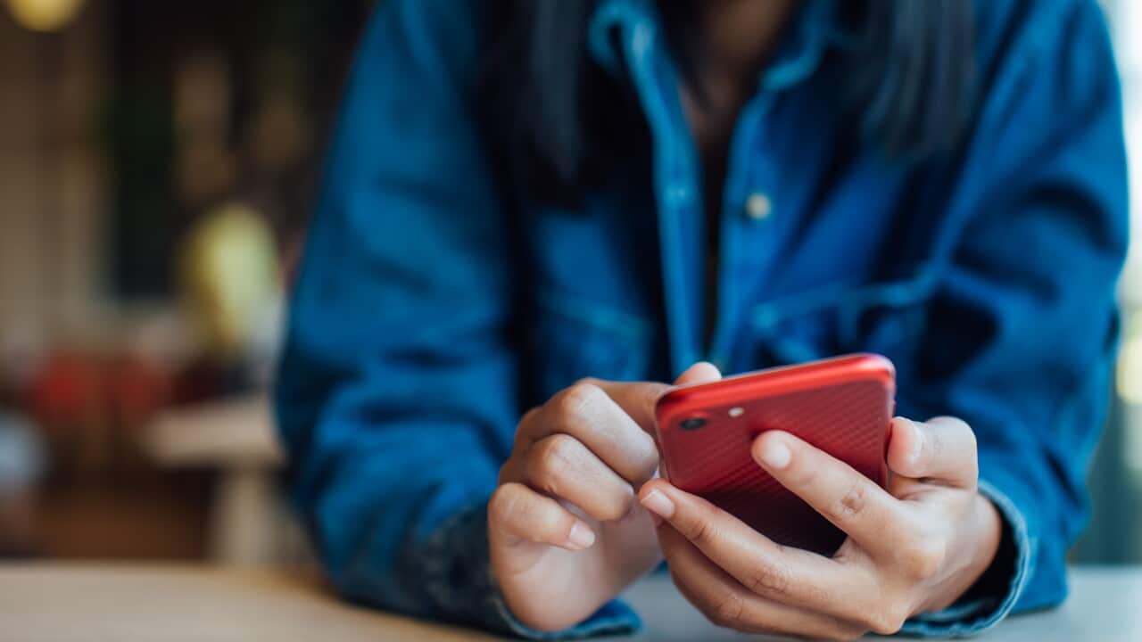 Midsection Of Woman Using Smart Phone On Table In Cafe