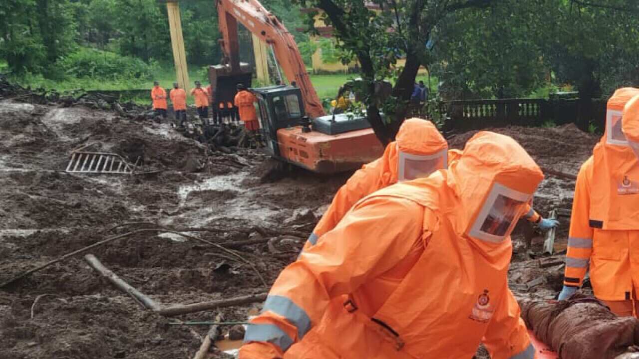 India's National Disaster Response Force personnel recovering the body of a landslide victim at Ratnagiri in the western state of Maharashtra