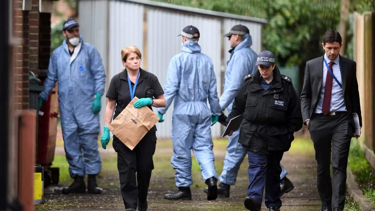 Police officers conduct a search of a bail hostel in south London
