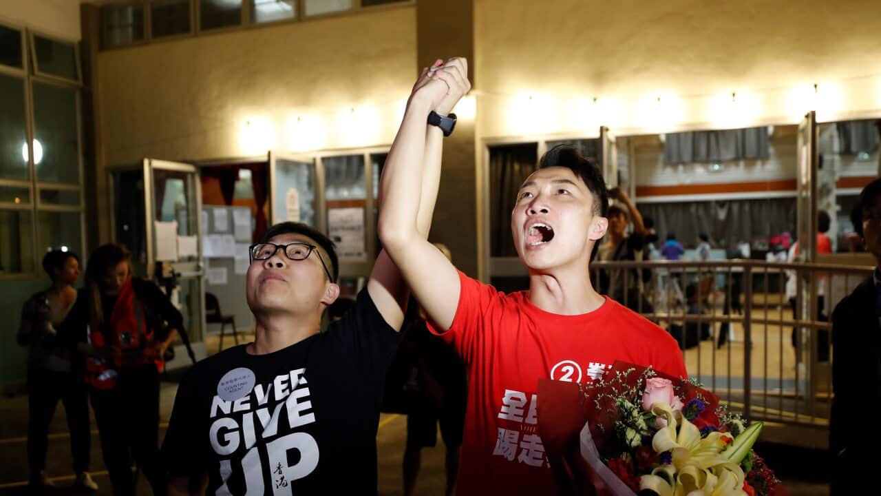 Pro-democracy candidate Jimmy Sham, right, celebrates with a supporter after winning his election in Hong Kong.