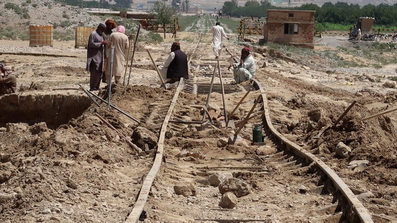 Workers repair a railway track that was damaged by floods following heavy rains on the outskirts of Quetta, Pakistan.