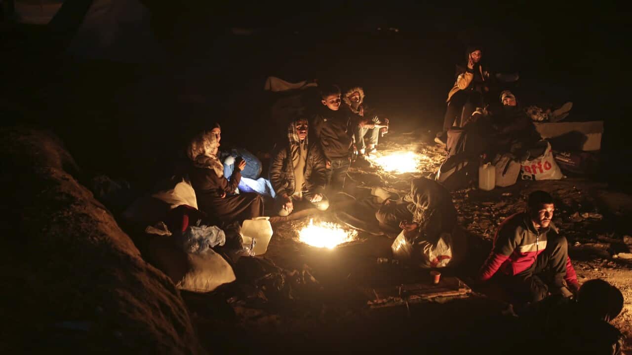 Displaced Palestinians warm themselves by a fire as they wait to return to their homes in the northern part of the Gaza Strip.