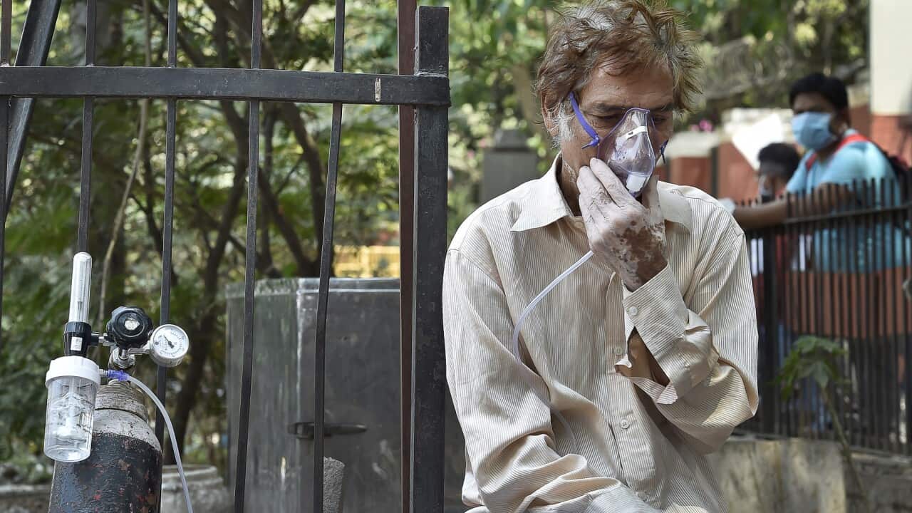 A Covid-19 patient on oxygen support waits outside LNJP Hospital for admission amid a shortage of beds