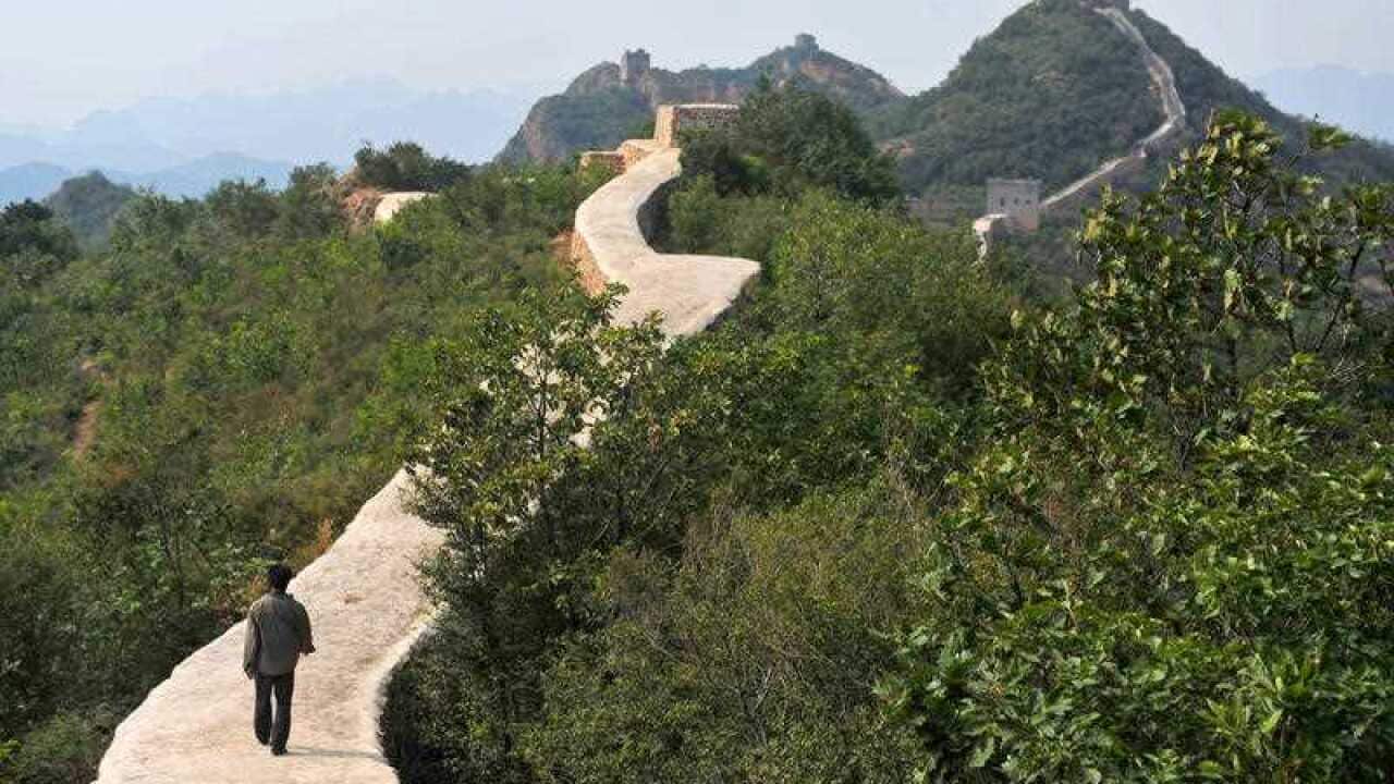 a villager walks across a restored section of the Great Wall in Suizhong County in northeastern China's Liaoning Province.