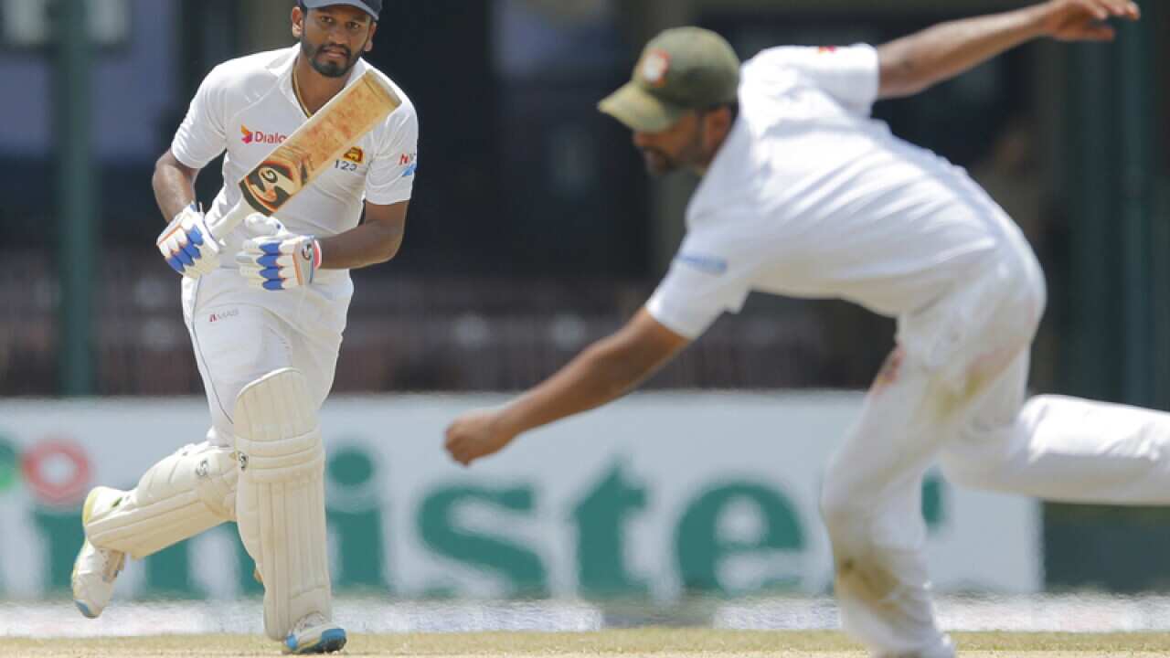 Sri Lanka's Dimuth Karunaratne watches his shot against Bangladesh