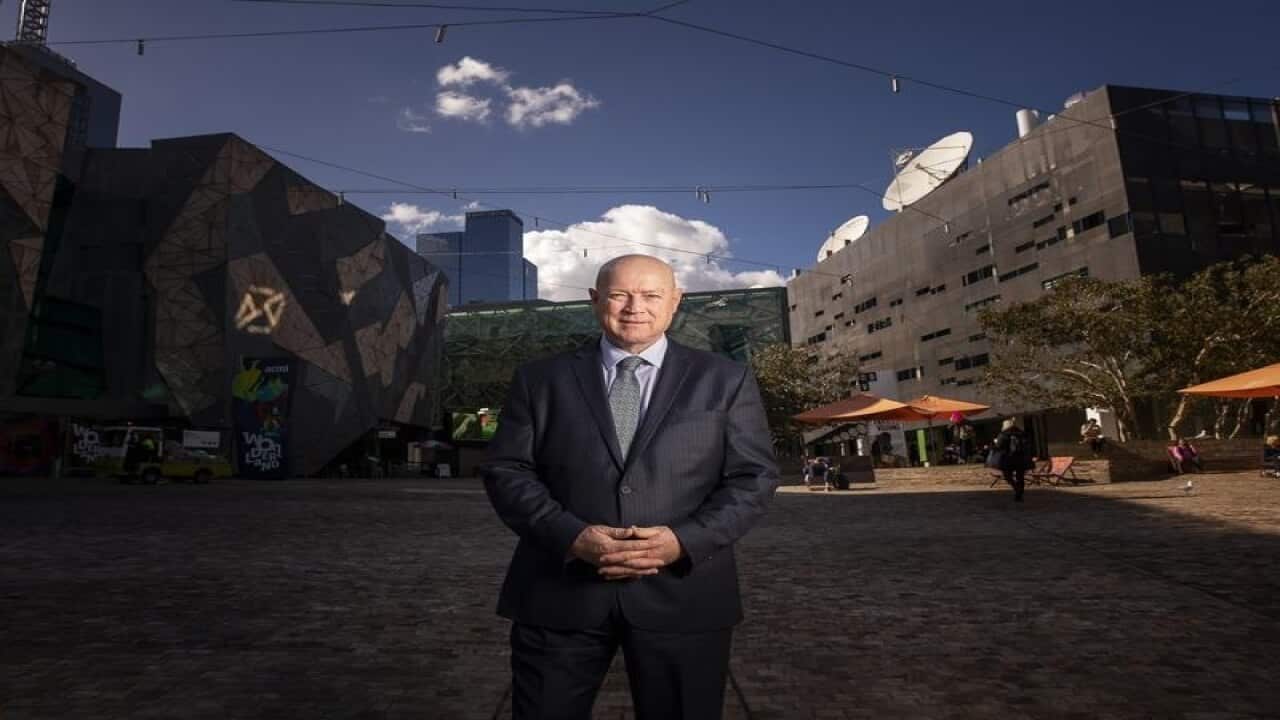 Simon Ambrose poses for a photograph at federation square.