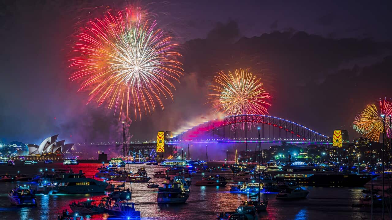 A view of the Opera House and Sydney Harbour bridge lit up by fireworks.