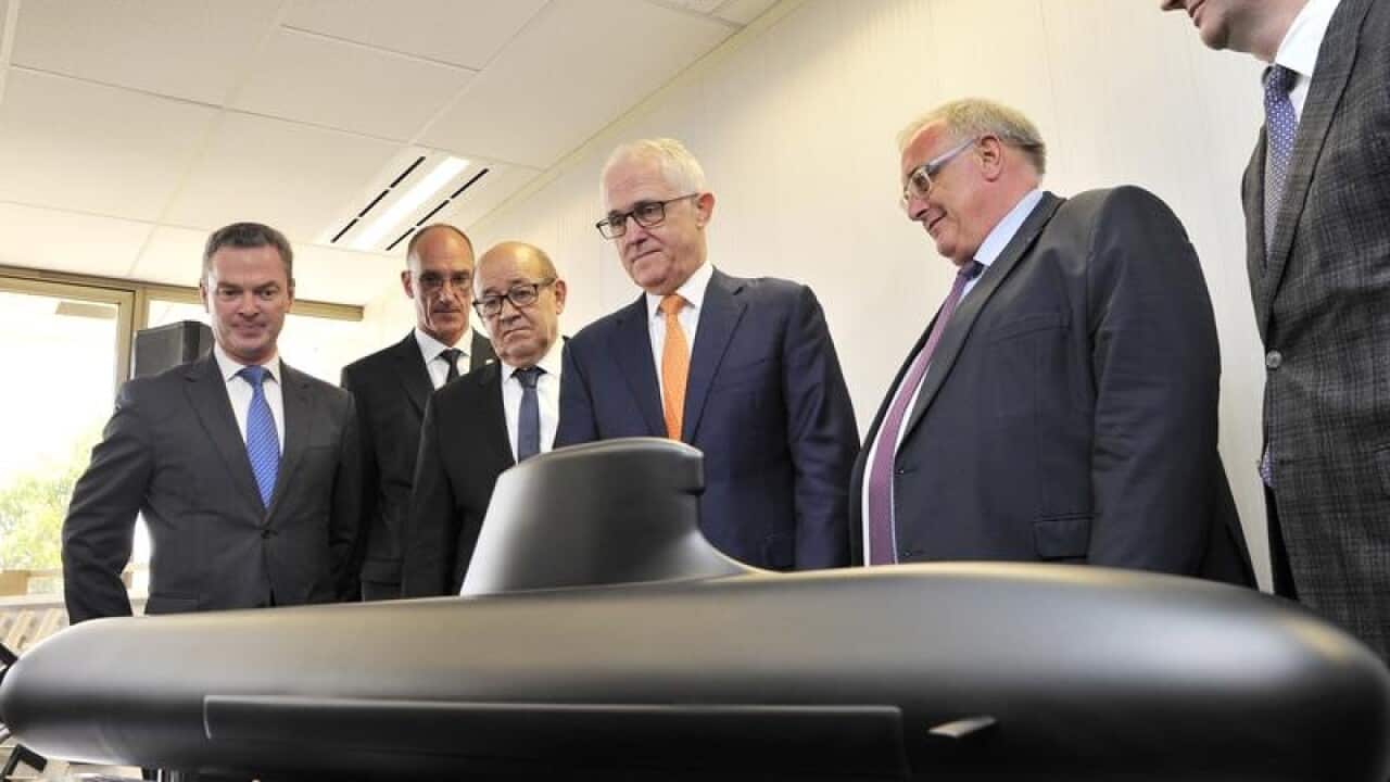 Malcolm Turnbull (C) looks at a model of a French-designed submarine
