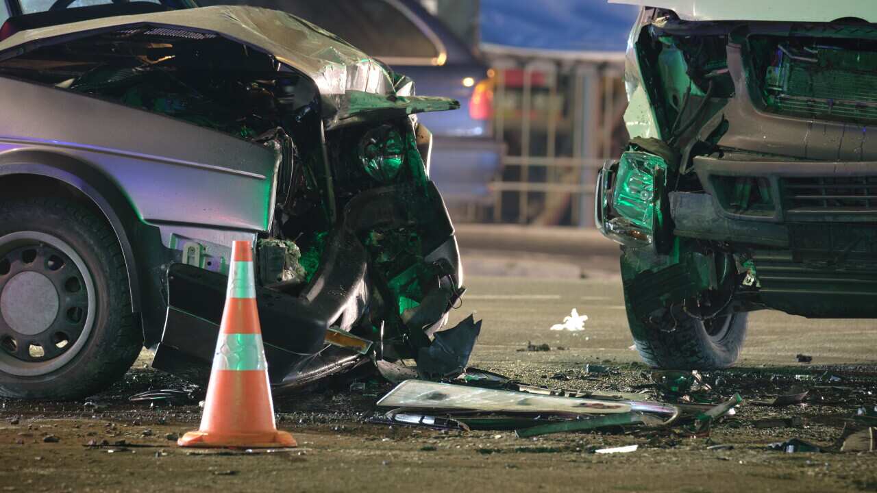 Damaged in heavy car accident vehicles after collision on city street crash site at night. Road safety and insurance concept