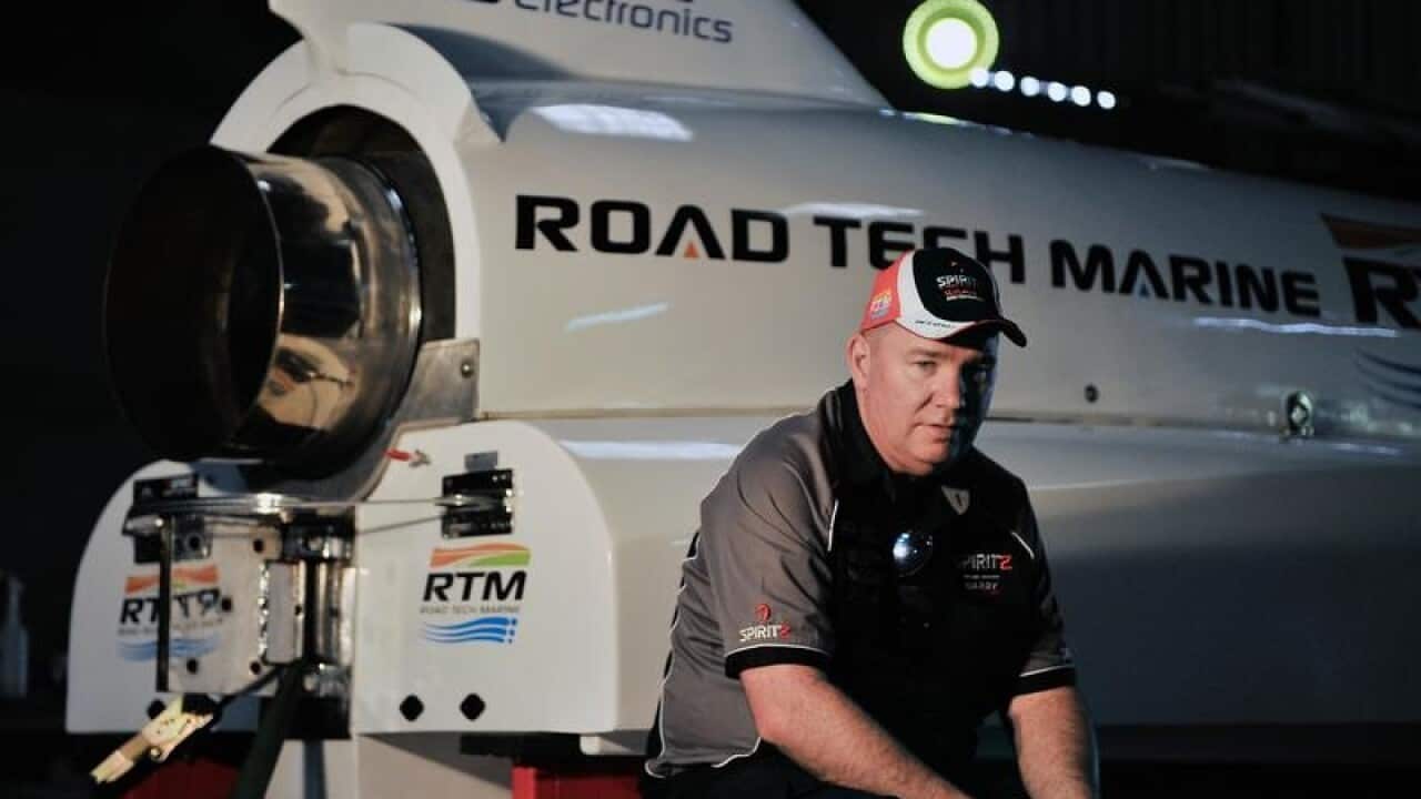 Dave Warby poses for a photograph in front of his boat.
