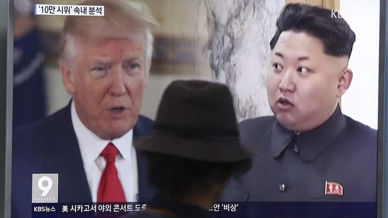 a man watches a television screen showing U.S. President Donald Trump and North Korean leader Kim Jong Un during a news program at the Seoul Train Station.