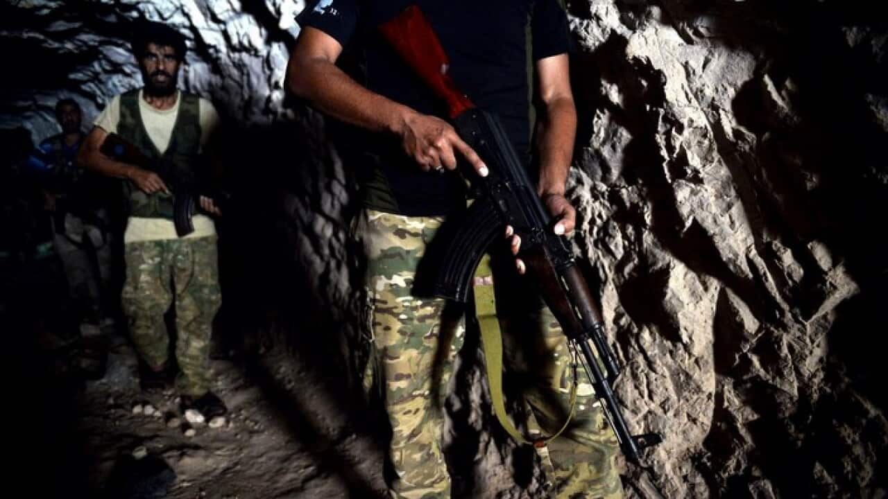 Fighters with the Free Syrian army leave a cave where they live, in the outskirts of the northern town of Jisr al-Shughur, Syria, west of the city of Idlib.