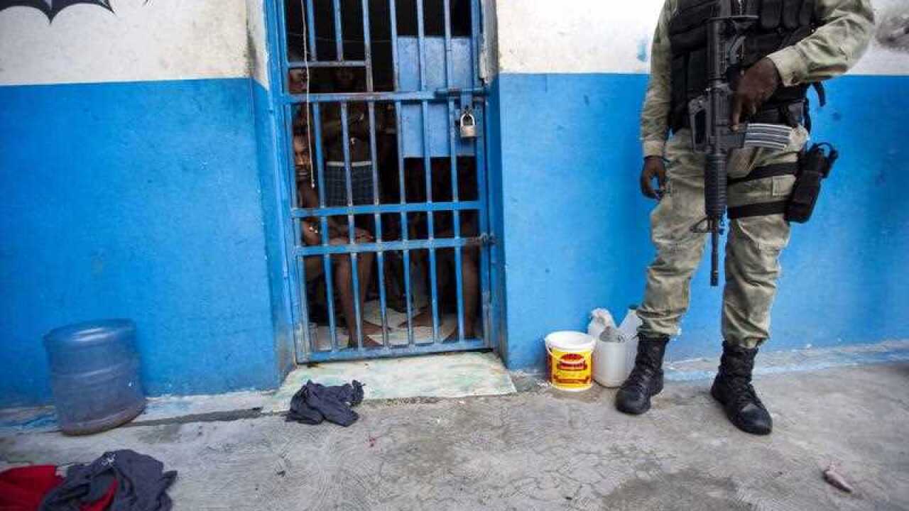 A police officer stands outside a room of inmates after a prison break at the Civil Prison in the coastal town of Arcahaiea, Haiti