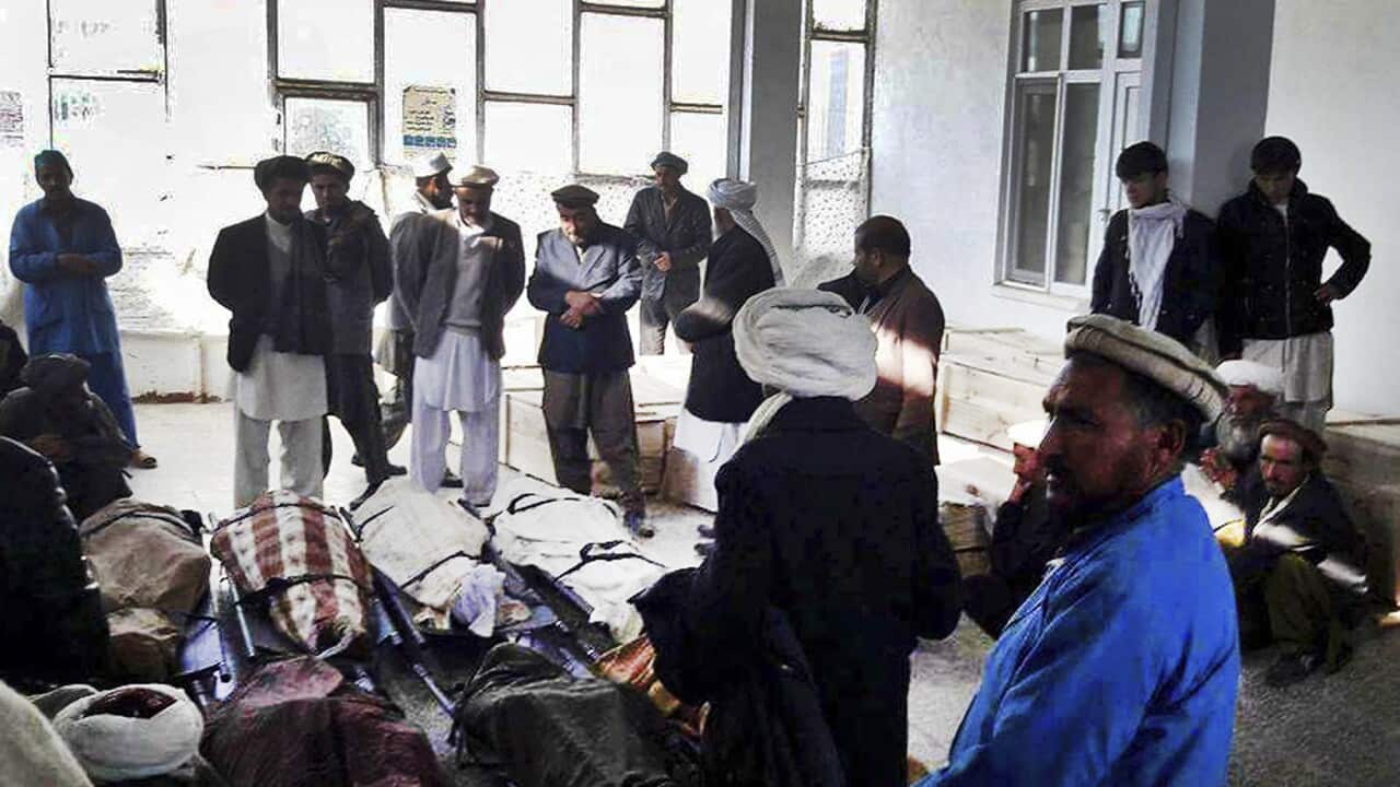 Afghan men gathered around several civilian dead bodies who have been killed by Taliban fighters in Ghor province, Afghanistan