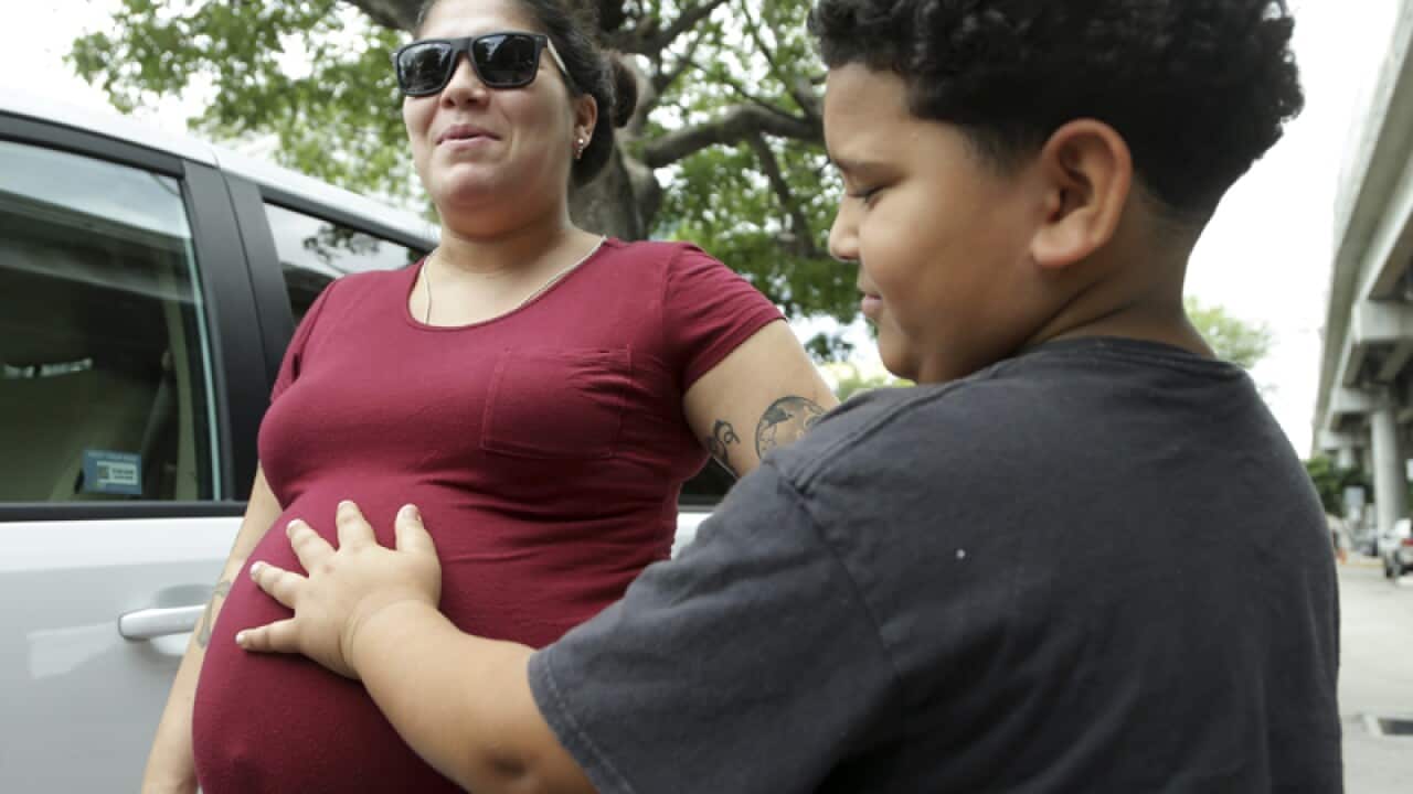 A boy touches the stomach of his pregnant mother in Miami