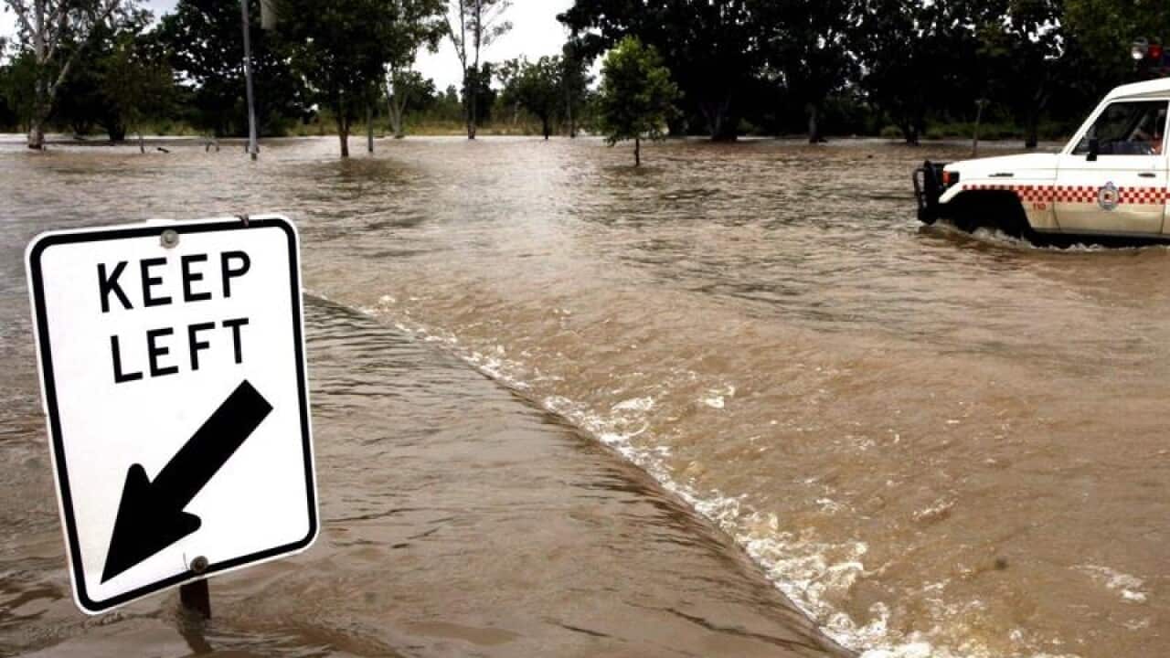 An emergancy vehicle make its way through flood waters in Katherine.