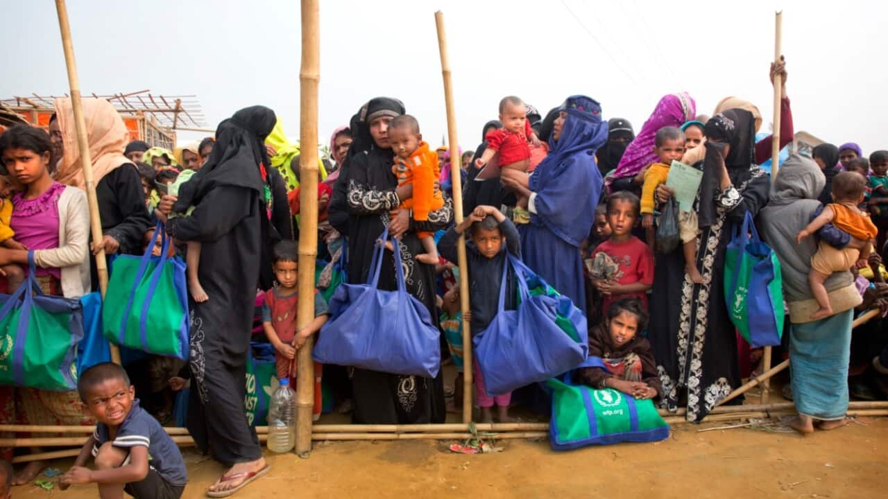 Rohingya Muslim women with their children stand in a queue outside a food distribution center at Balukhali refugee camp, Bangladesh 