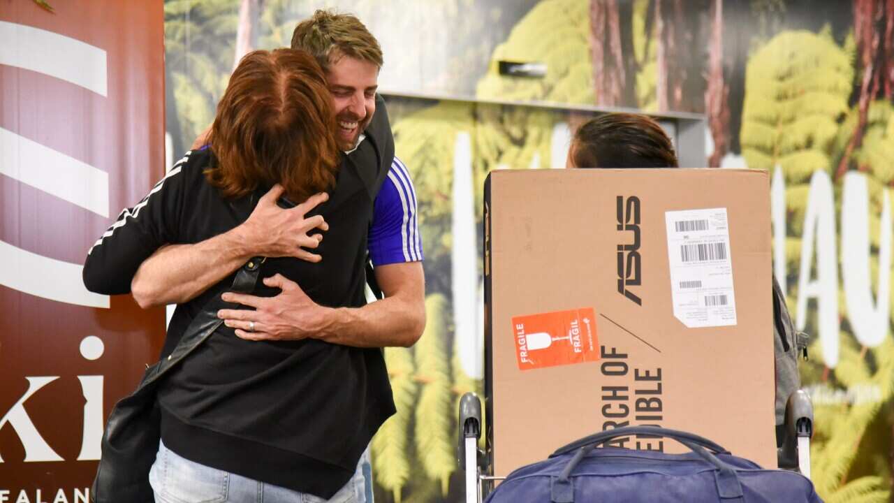 Families and loved ones embrace after landing on the first Air New Zealand flight to land in Wellington on 19 April 2021.  