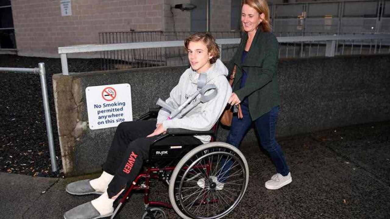 Sam Kanizay leaves hospital, accompanied by his mother Jane.