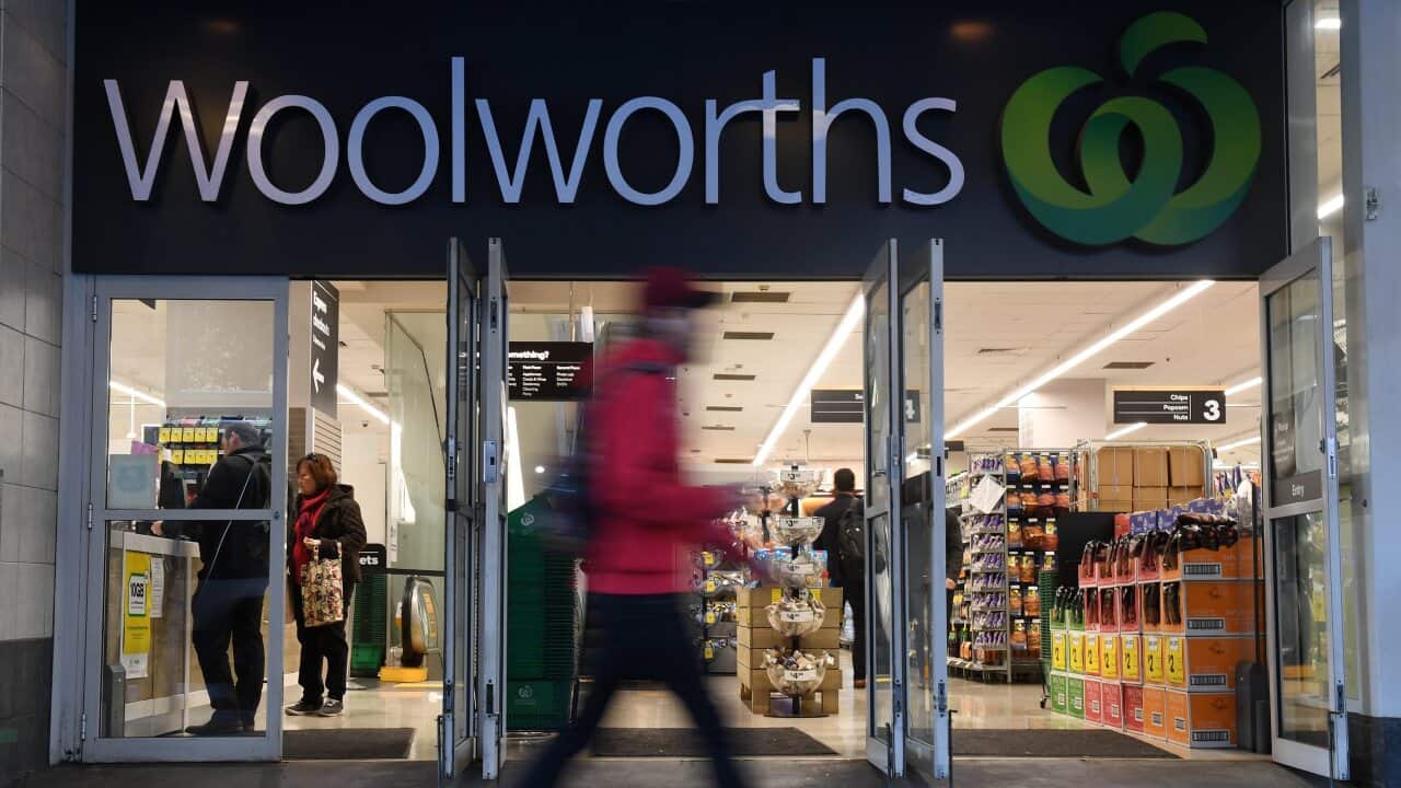 Shoppers walk past a Woolworths store in Sydney.