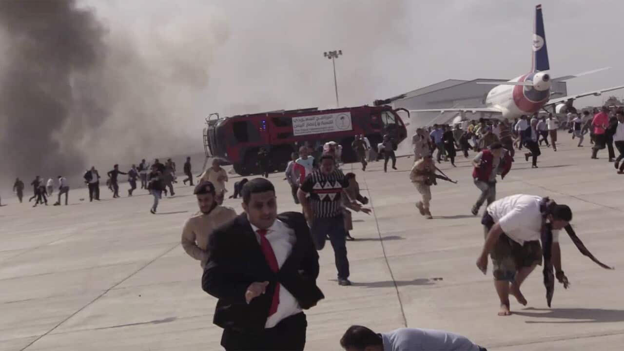 People run following an explosion at the airport in Aden, Yemen.