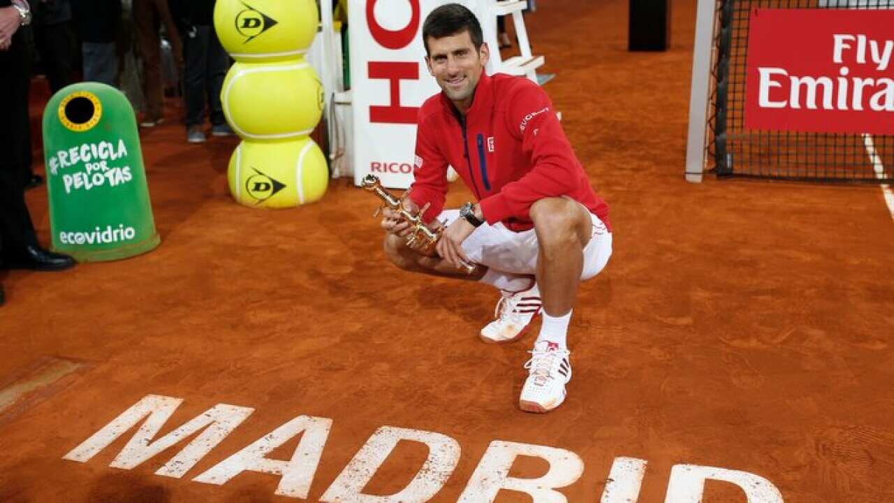 Novak Djokovic, from Serbia, poses for photographers with his trophy after winning the Madrid Open tennis tournament final match against Andy Murray, from Britain in Madrid, Spain, Sunday, May 8, 2016. (AP Photo/Francisco Seco)