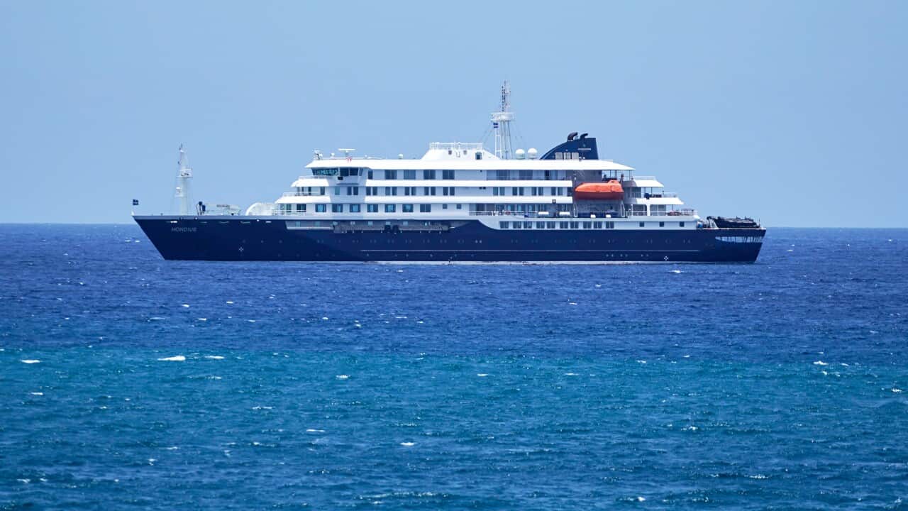 A small cruise ship with a blue hull in the ocean