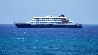 A small cruise ship with a blue hull in the ocean