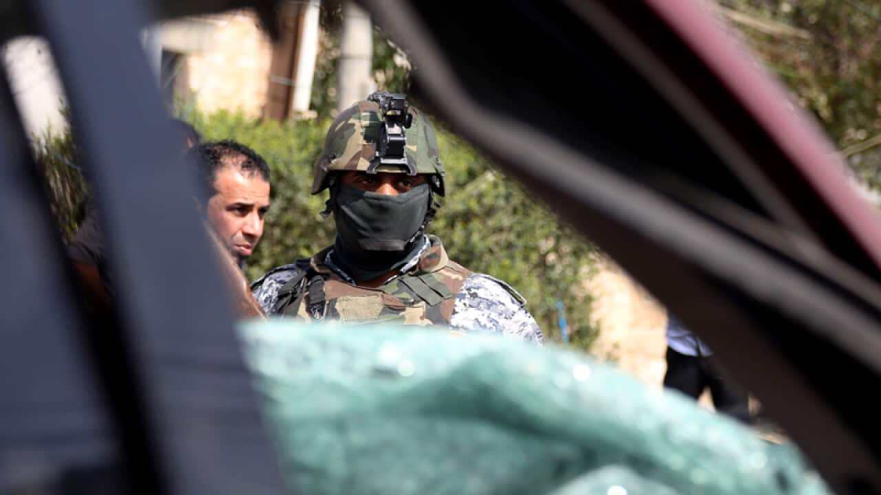 An Iraq policeman stands guard at the site of a car bomb attack