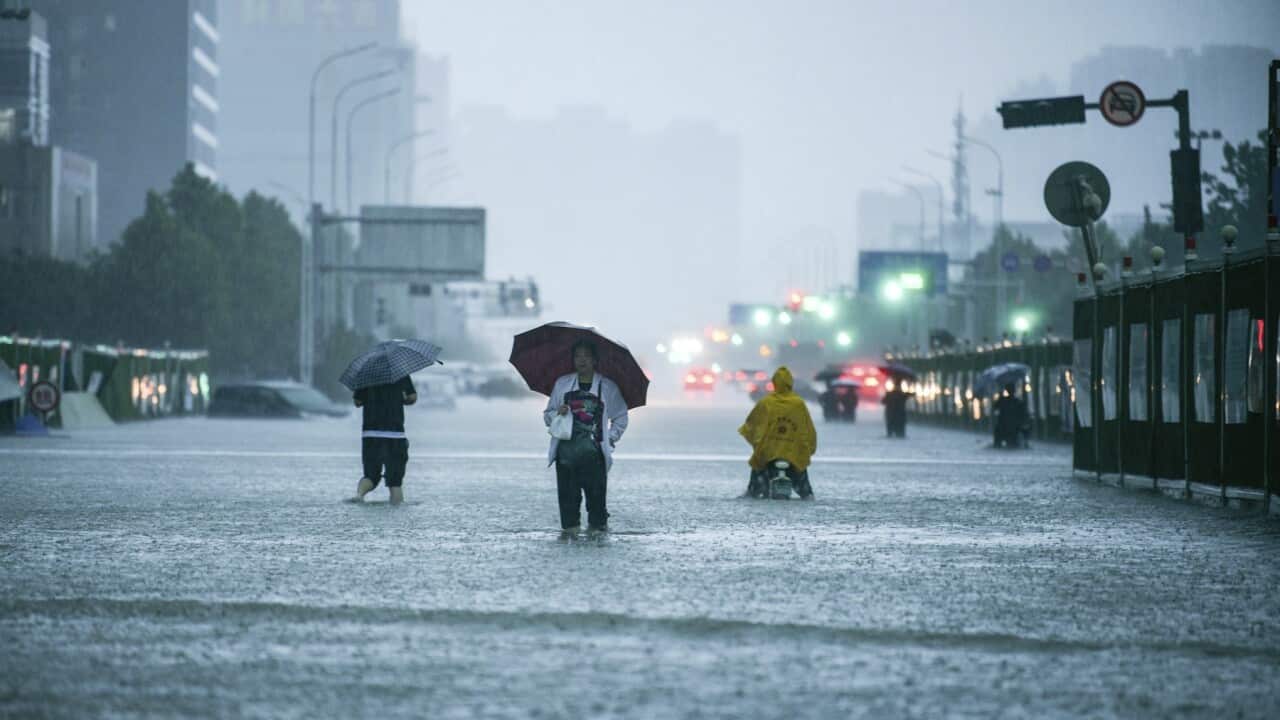 People walking through a rainstorm in Zhengzhou city, China