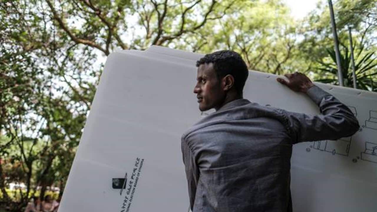 An electoral officials carries polling booths at a distribution center.jpg