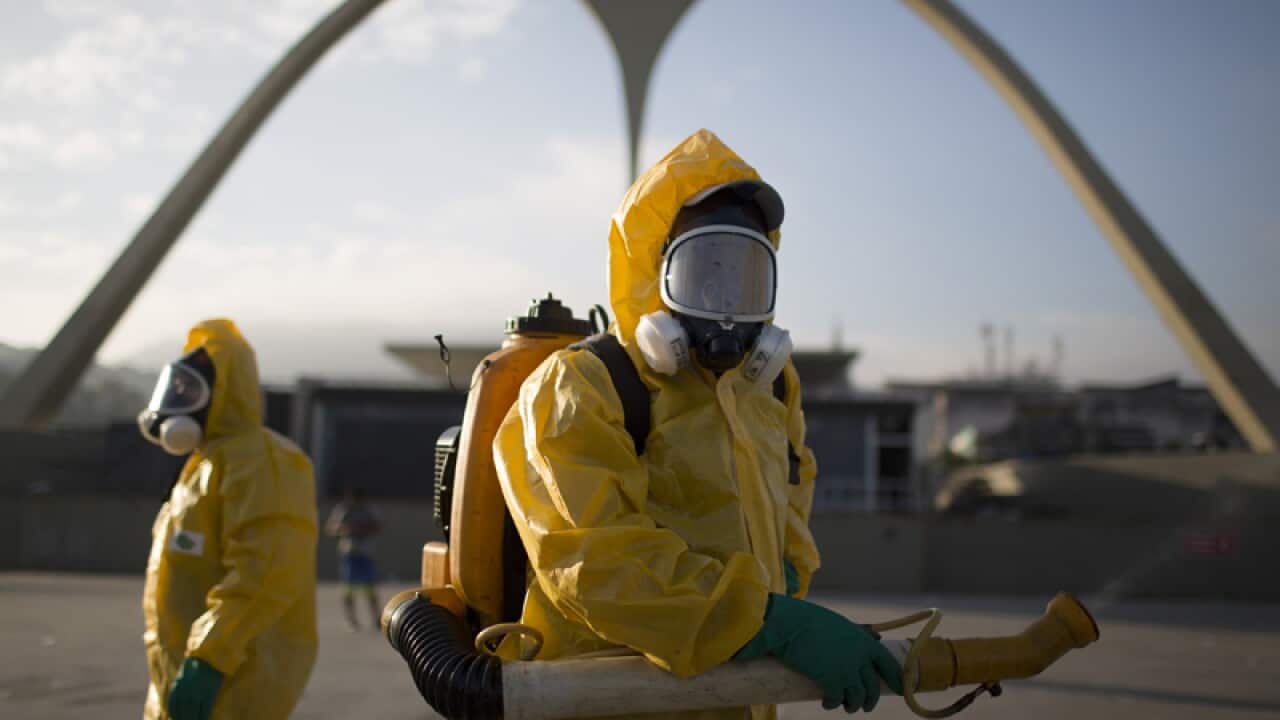 Health workers spray insecticide to combat the Zika virus