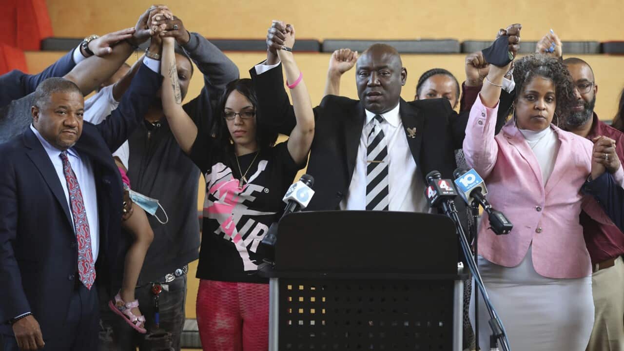 Attorney Ben Crump stands with members of Andre Hill's family, including daughter Karissa Hill and sister Shawna Barnett, during a press conference.