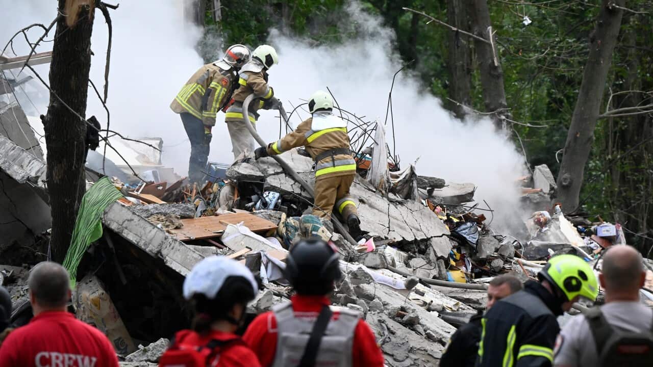 Firefighters put out fires on the ruins of a section of a nine-storey apartment block.