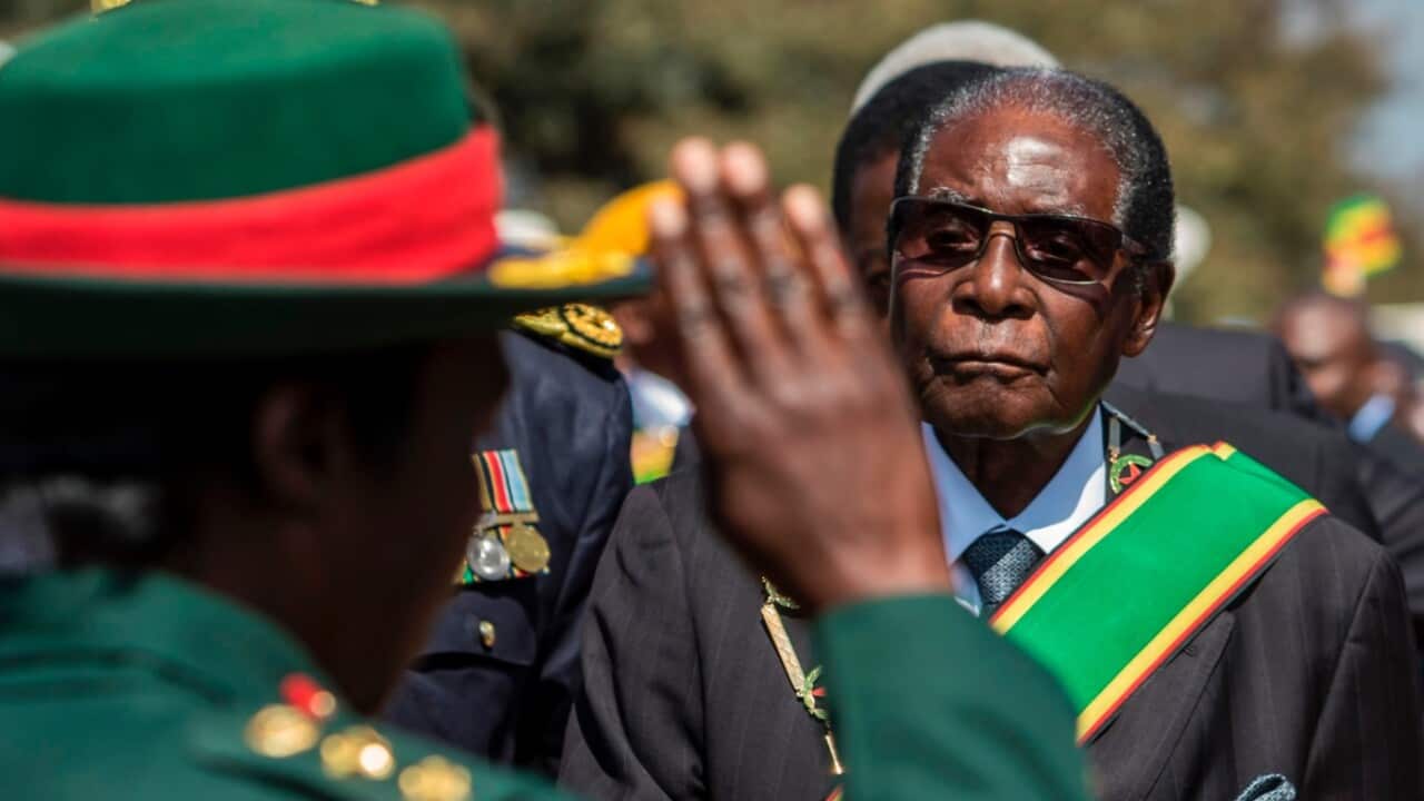 File image: Former Zimbabwe President Robert Mugabe (R) inspects a guard of honour during official Heroes Day commemorations in August 2017 