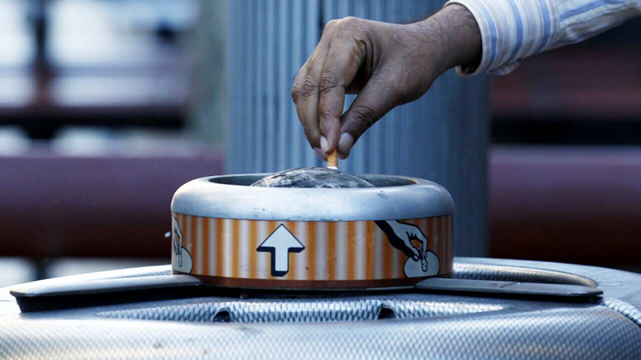 A person puts out a cigarette