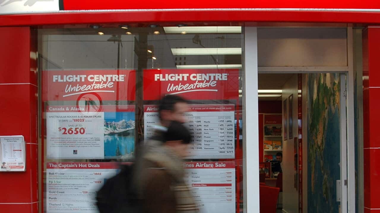 A person walks by travel agent Flight Centre retail outlet