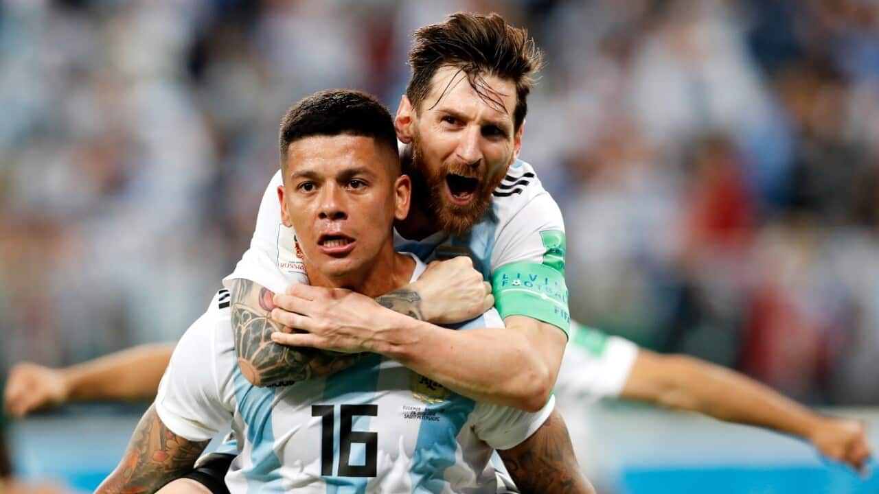 Marcos Rojo of Argentina celebrates with teammate Lionel Messi (top) after scoring
