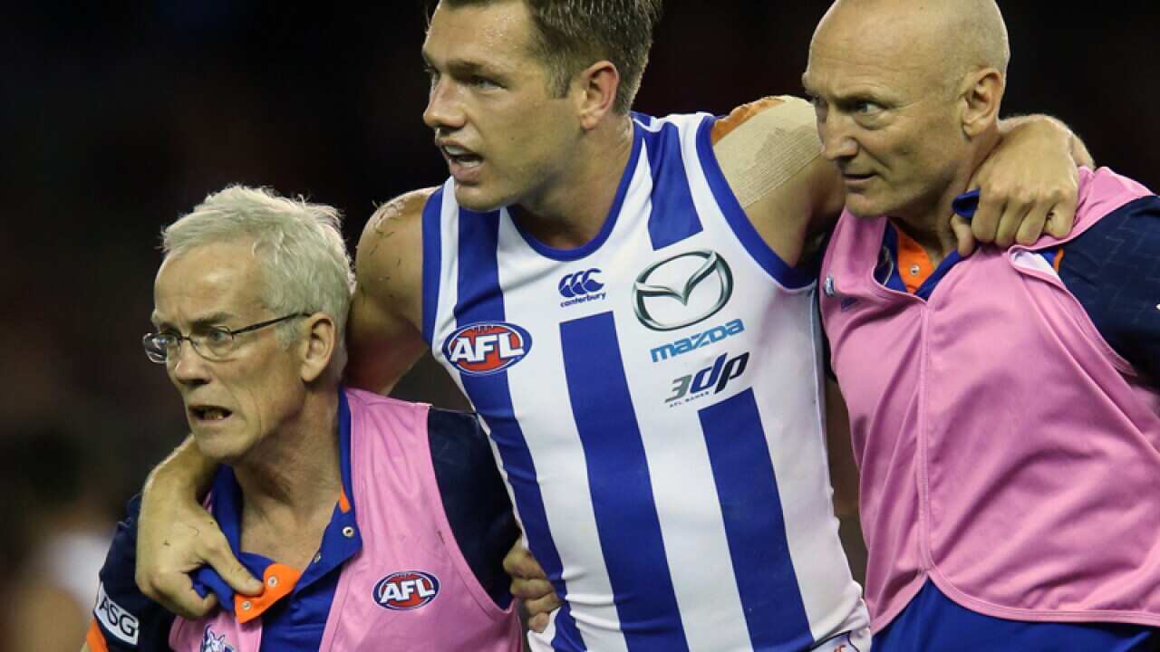 Shaun Higgins leaves the ground injured for North Melbourne