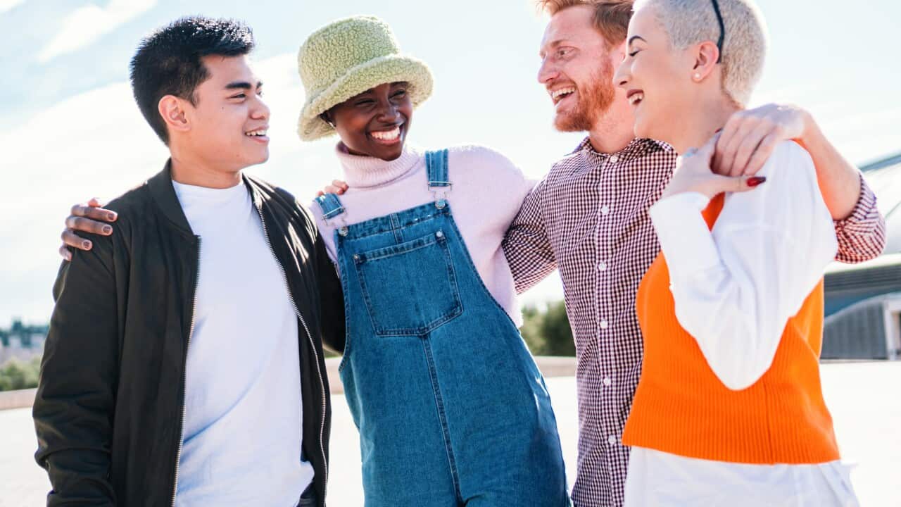 Two women and two men at park talking laughing and enjoying their time. friends hanging out and talking outdoors in summer park