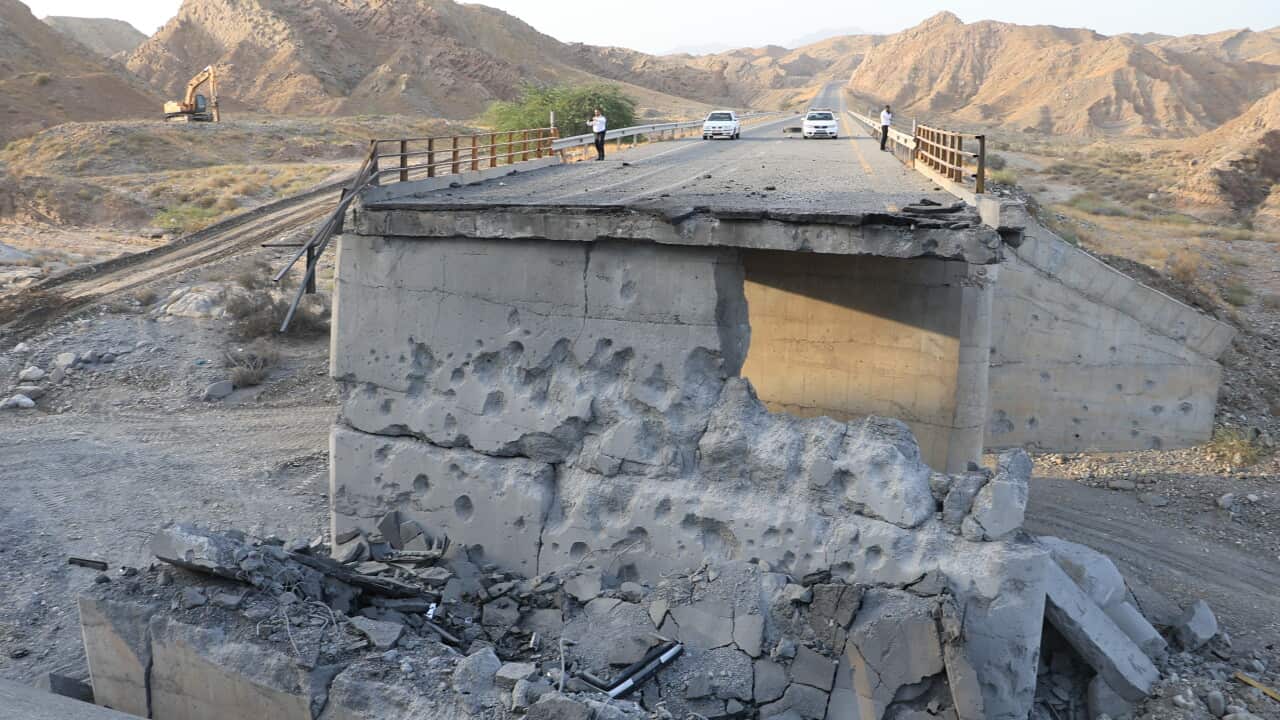 People stand on a bridge destroyed after a strike in Hormozgan province, southern Iran, Saturday, July 18, 2026.