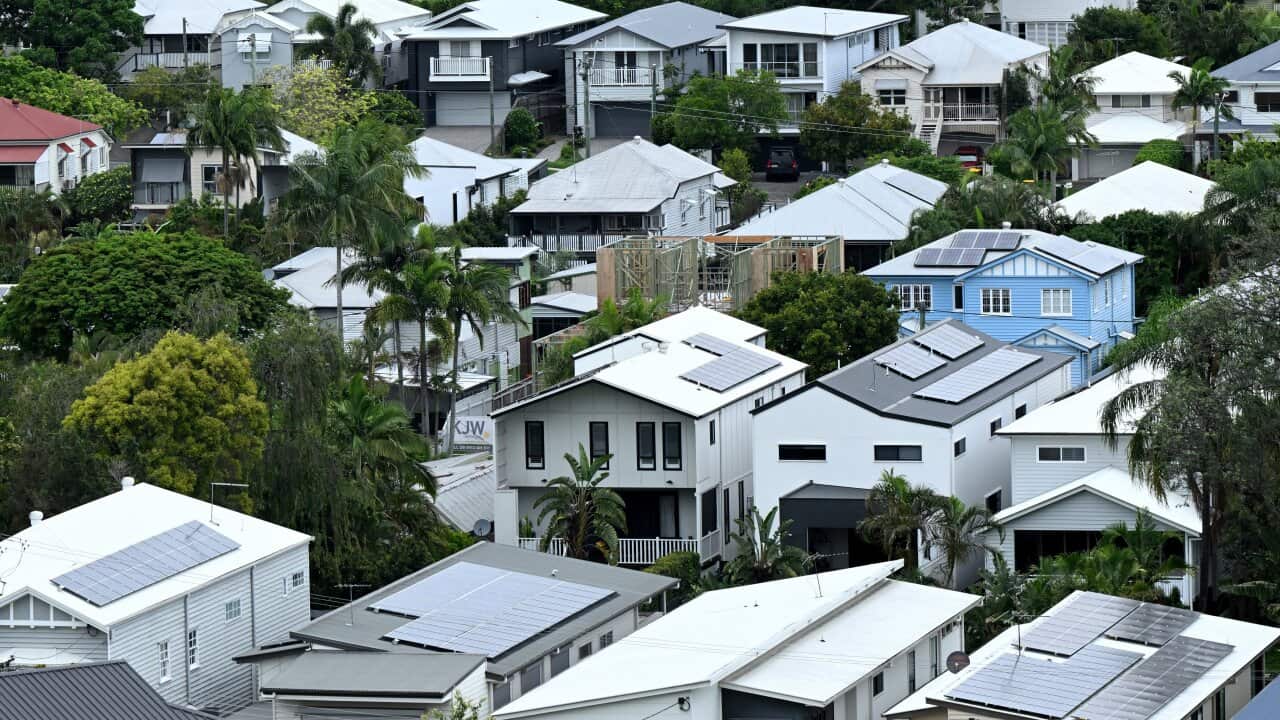 Several rows of houses among green trees.